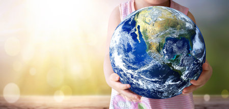 earth day concept, A child holds the world on arid natural sky background.の写真素材