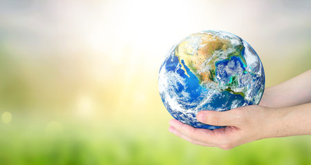 Earth Day, Human hands holding earth global on blurred nature background. Elements of this imageの写真素材