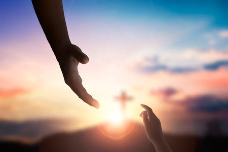 God's helping hand and cross on sunset backgroundの写真素材