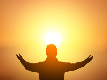 Human hands open palm up worship on sunset sky background.の写真素材
