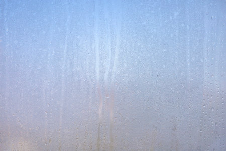 Background of natural water condensation, window glass with high air humidity, large drops drip. Collecting and streaming downの写真素材