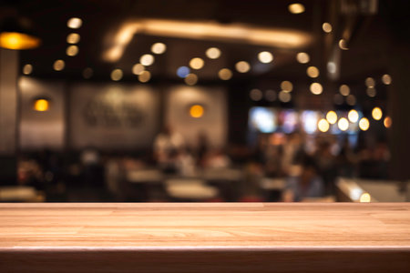 Empty wooden table in front of abstract blurred background of coffee shopの写真素材