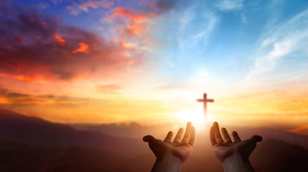 Human hands holding a cross on the top of the mountain at sunset backgroundの写真素材