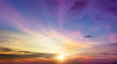 Sunset sky background with clouds and rays of light. Nature composition.の写真素材