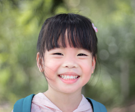 Portrait of a cute little asian girl smiling in the parkの写真素材