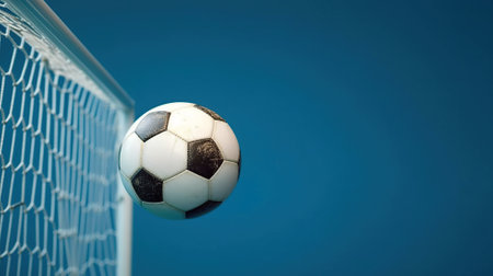 Soccer ball in goal on blue background Generative AIの素材