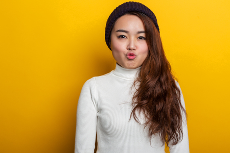 Young Chinese girl, various expressions on a yellow backgroundの写真素材