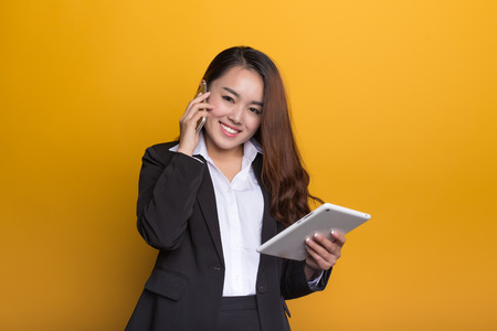 Chinese woman in formal attire with a yellow backgroundの写真素材
