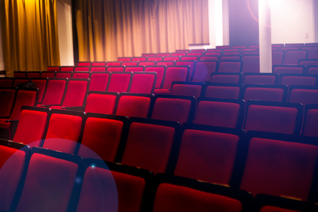 Auditorium in a theater or cinema, spotlights pass through empty seatsの写真素材