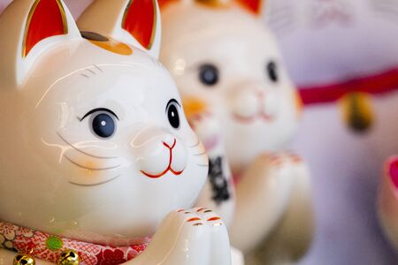 "A group of ceramic Japanese lucky cats in the display cabinet (Japanese: Lucky Cat Chinese: Peace, lucky blessing, good luck, good fortune, ten thousand)"の写真素材