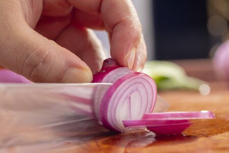 Close-up chef is cutting red onionの写真素材