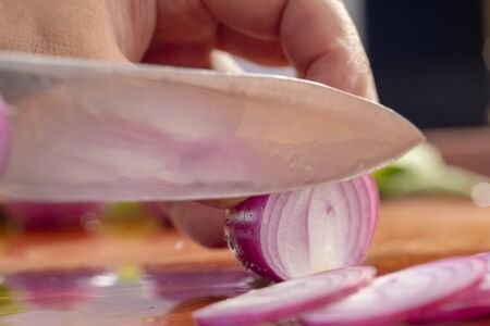 Close-up chef is cutting red onionの写真素材
