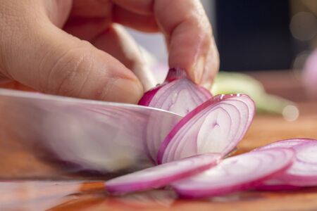 Close-up chef is cutting red onionの写真素材
