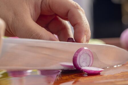 Close-up chef is cutting red onionの写真素材