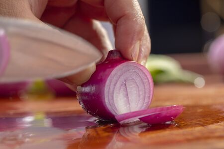 Close-up chef is cutting red onionの写真素材