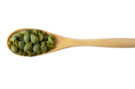 Wooden spoon with fresh pumpkin seeds on white backgroundの写真素材