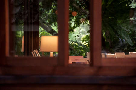 Elegant coffee house in the forest garden, table lamp in the windowの写真素材