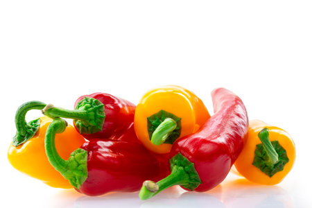 Red and yellow fresh bell peppers on a white backgroundの写真素材