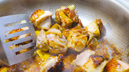 Stir -fried tender chicken pieces in a close -up potの写真素材