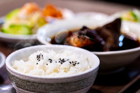 Steaming White Rice and Home-Style Dishes on a Tableの写真素材