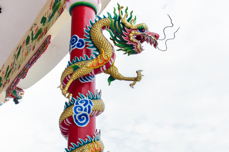 Dragon winding around the pole in chinese shrine in Thailandの写真素材