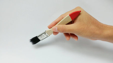 Man hand holding Paint Brush on a white background.(Natural lighting)の写真素材