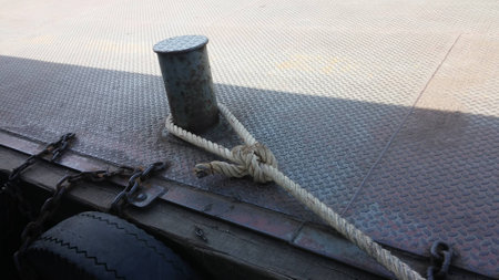 The rope looped steel pins to fastening the ferryboat against the pontoon boatsの写真素材