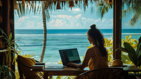 Woman working on laptop computer in cafe on the beach. Freelance business conceptの素材