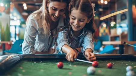 Mother and daughter playing billiards in cafe. Focus on girlの素材