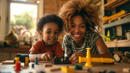 African american mother and son playing with blocks at table in classroomの素材