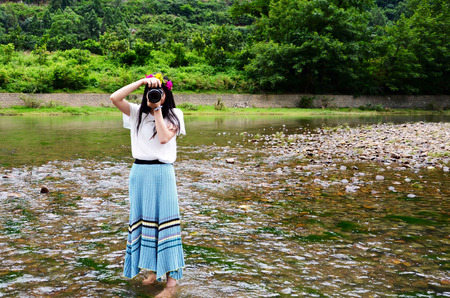 Woman standing in the river taking picturesのeditorial素材