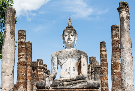 Large ancient white Buddha image and many pillars surroundの写真素材