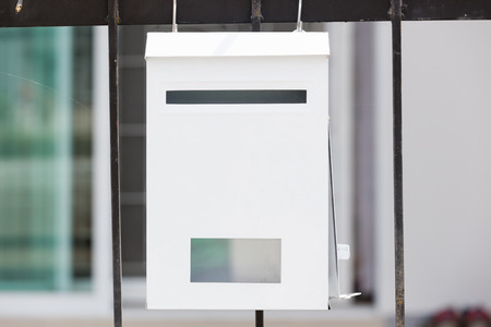Mailbox hanging on a fence at home.の写真素材