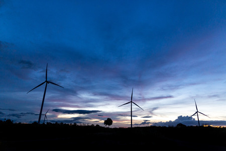 Silhouette of wind power station on sunsetの写真素材