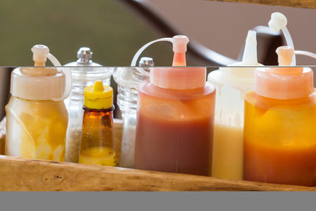 Different kinds of sauce bottles were placed on the dining table.の写真素材