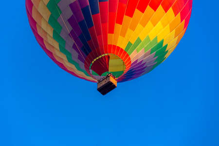 Colorful hot air balloon flying in the bright blue skyの写真素材