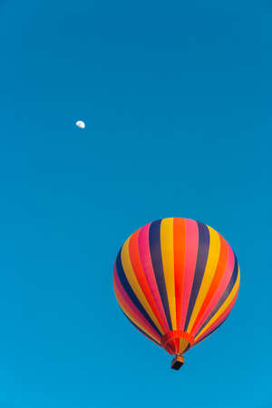 Colorful hot air balloon flying in the bright blue skyの写真素材