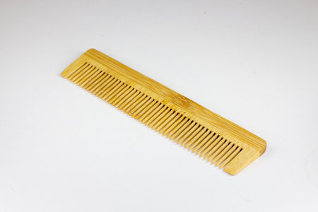 Wooden comb on a white background, isolated, close-up