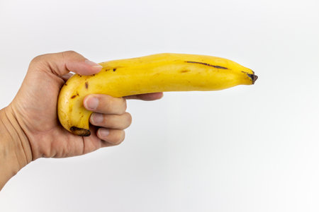 Hand holding banana on white background, Banana is a fruit of Thailand.の写真素材