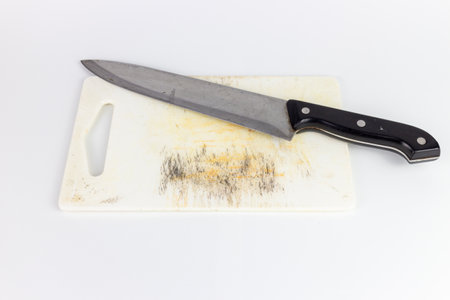 Dirty knife and cutting board isolated on white background with clipping path.