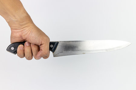 Knife in hand on a white background. Close-up.の写真素材