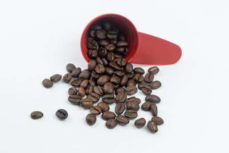 Coffee beans in a red cup isolated on white background.の写真素材