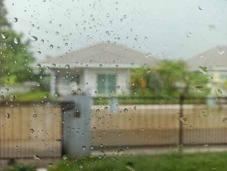 Rain drops on the glass with a blurred background of the house.