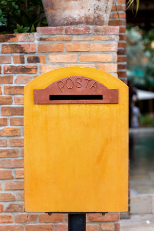 Yellow mail box on brick wall. Mailbox on the street.の写真素材