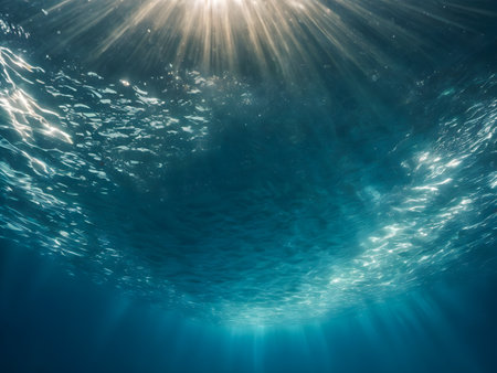 Underwater view of the sunbeams shining through the water surfaceの素材
