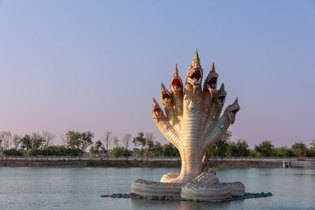A large seven-headed naga statue in the middle of the water at Wat Ban Rai, Nakhon Ratchasima, Thailand.の写真素材