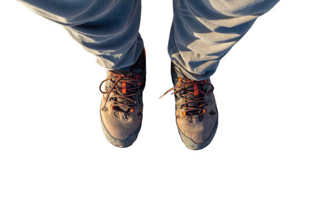 A pair of old, dirty leather work boots with brown laces on a white backgroundの写真素材