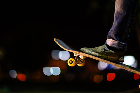 Close up of a skateboard with skater's feet on a bokeh background.の写真素材