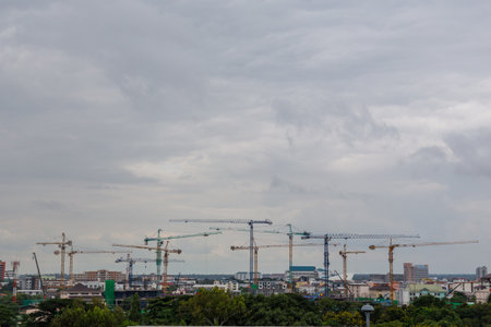 New high-technology industrial power plant construction site in an urban environment with blue sky and tall cranesの写真素材