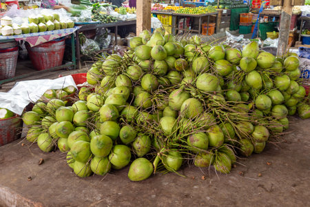 Fresh and colorful organic produce, including coconuts, are displayed on vibrant stalls in Thailand.の写真素材